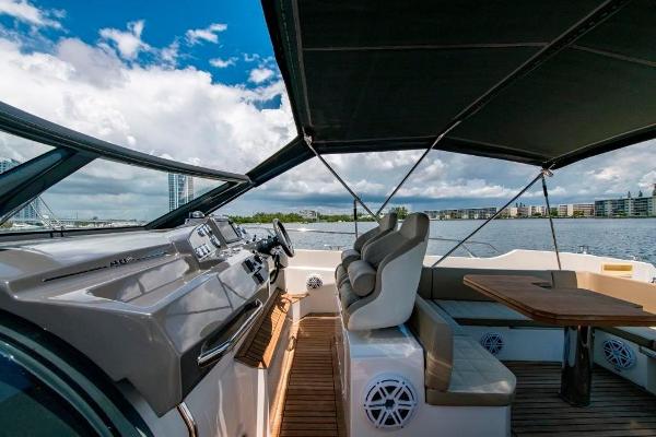 Slide: The Image of 2015 Absolute 40 STL yacht cockpit with seating and table, waterfront view. - 22