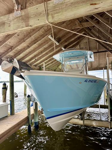 Slide: The Image of 2021 Albury Brothers 27 boat docked under wooden shelter. - 2