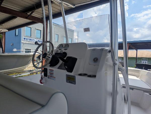 Slide: The Image of 2024 ALK2 Powerboats 22 CRX console with steering wheel and gauges, docked at marina. - 12