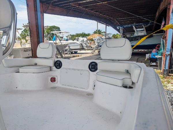 Slide: The Image of 2024 ALK2 Powerboats 22 CRX interior with white seating, docked under a shelter. - 4