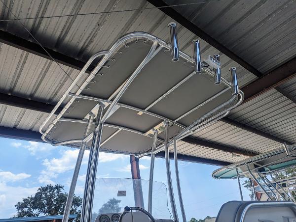 Slide: The Image of 2024 ALK2 Powerboats 22 CRX T-top under a metal roof, showcasing rod holders. - 5