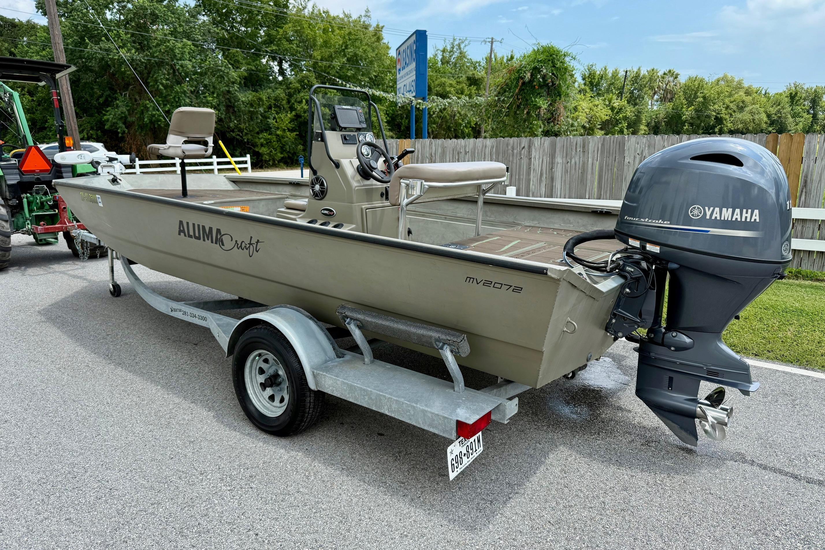Slide: The Image of 2021 Alumacraft 2072 All Weld MV CC boat on trailer with Yamaha outboard motor. - 2