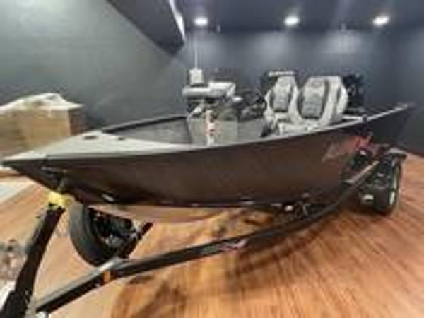 Slide: The Image of 2023 Alumacraft Escape 165 CS fishing boat on trailer in showroom. - 1