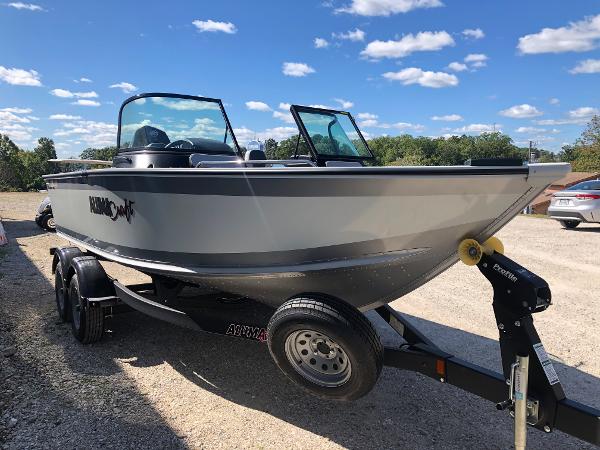 Slide: The Image of 2024 Alumacraft Trophy 195 boat on a trailer under a clear blue sky. - 3