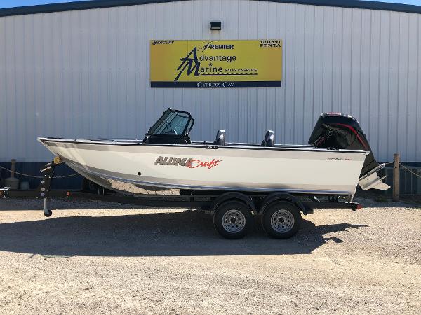 Slide: The Image of 2024 Alumacraft Trophy 195 boat on trailer outside marine dealership. - 4