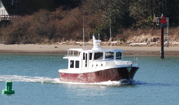 Slide: The Image of 2025 American Tug 395 cruising on a calm river near the shore. - 23