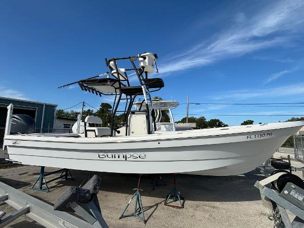 Slide: The Image of 2014 Andros Tarpon 26 boat on stands, white hull, clear sky background. - 2