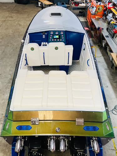 Slide: The Image of 1991 Apache POKER RUN CUSTOM speedboat with white seating and blue dashboard in a workshop. - 10