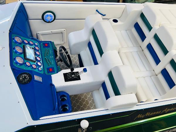 Slide: The Image of 1991 Apache POKER RUN CUSTOM boat interior with white and blue seating and control panel. - 16