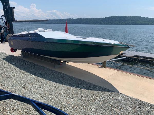 Slide: The Image of 1991 Apache POKER RUN CUSTOM speedboat docked by a scenic lake. - 2
