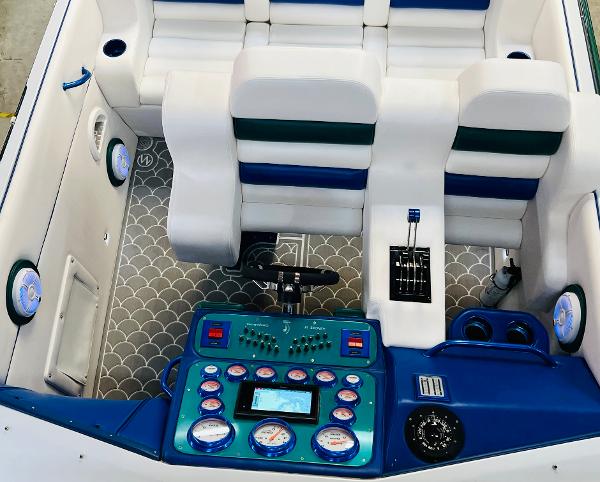 Slide: The Image of 1991 Apache POKER RUN CUSTOM boat interior with white and blue seats, control panel, and gauges. - 20