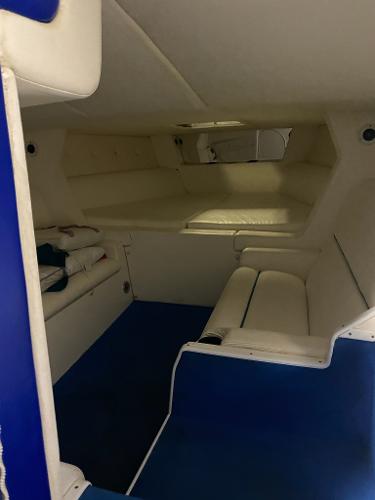Slide: The Image of Interior cabin of a 1991 Apache Poker Run Custom boat with white and blue seating. - 8