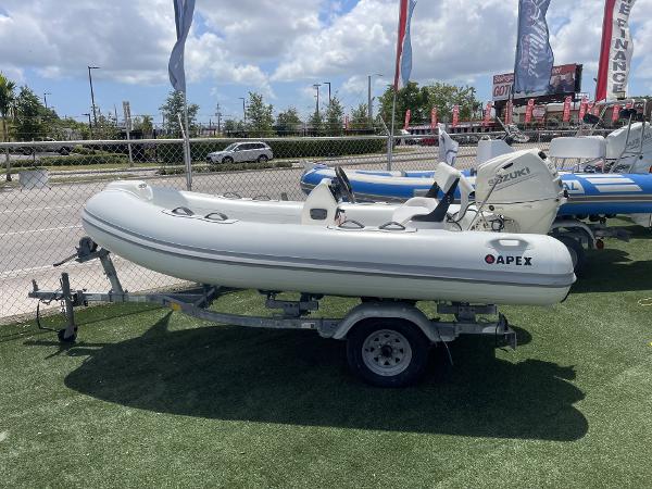 Slide: The Image of Apex A12 inflatable boat on trailer, 2021 model, displayed outdoors. - 1