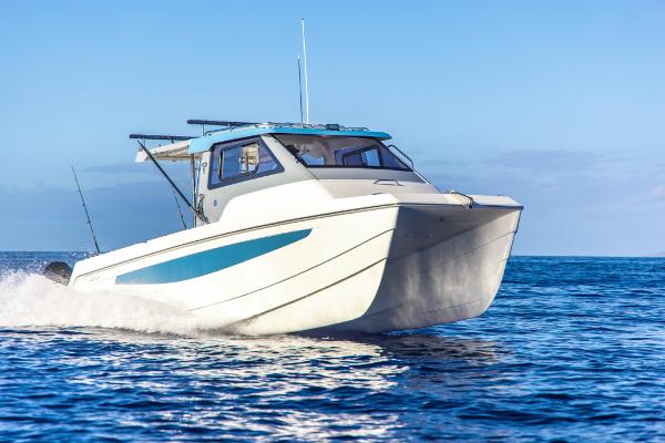 Slide: The Image of 2023 Aquila 28 Molokai Cuddy boat cruising on open water. - 1