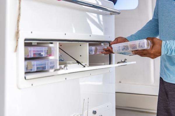 Slide: The Image of Man organizing tackle boxes on 2023 Aquila 28 Molokai Cuddy boat. - 31