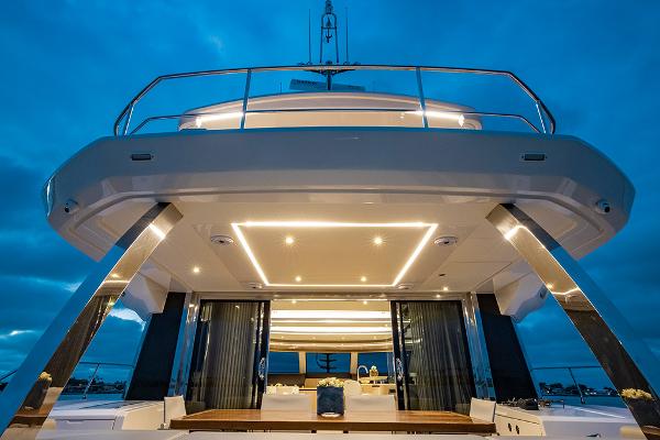 Slide: The Image of Aquila 70 Luxury yacht 2023 model, illuminated deck at dusk. - 14