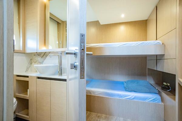 Slide: The Image of 2023 Aquila 70 Luxury yacht cabin with bunk beds and modern bathroom. - 23