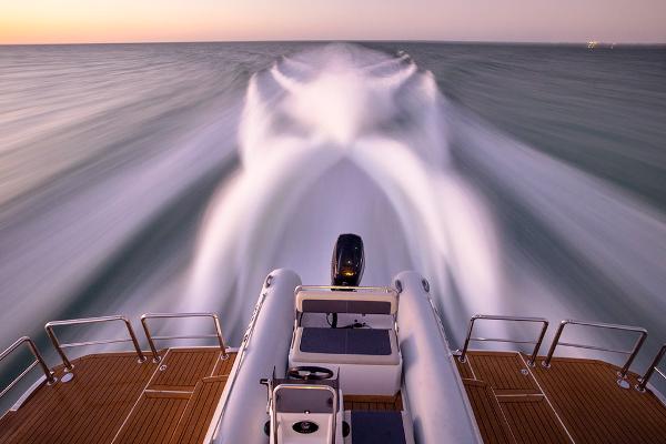 Slide: The Image of 2023 Aquila 70 Luxury yacht speeding on open water at sunset. - 8