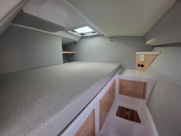 Slide: The Image of 2024 ArrowCat 320 cabin interior with bed, storage, and skylight. - 6