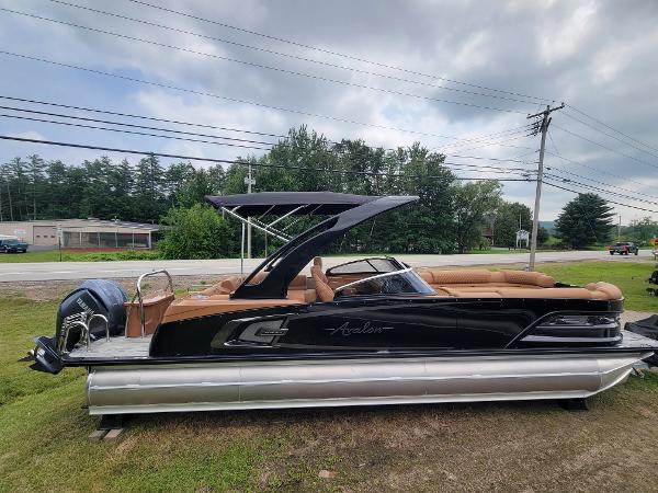 Slide: The Image of 2024 Avalon Excalibur WQL 27 Tri-Toon boat with black and tan design. - 2