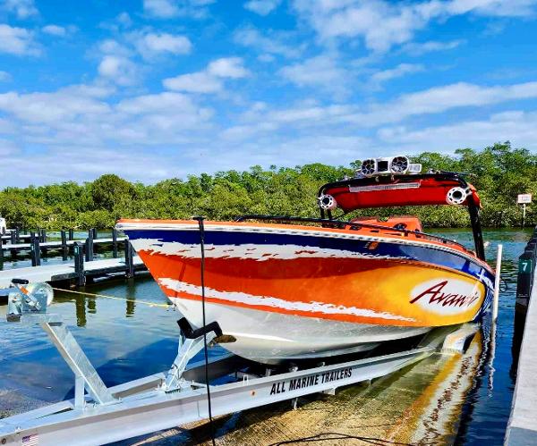 Slide: The Image of 2008 Avanti 36 speedboat on trailer at marina, vibrant orange and white design. - 2