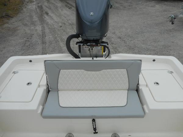 Slide: The Image of 2024 Avenger 26 Avenger boat with cushioned seating and outboard motor. - 8