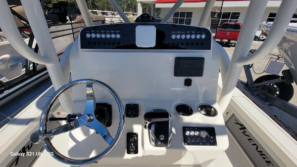 Slide: The Image of 2024 Avenger AV26 boat dashboard with steering wheel and control panel. - 13