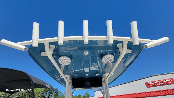 Slide: The Image of 2024 Avenger AV26 boat with rod holders and speakers, photographed from below against a clear blue sky. - 19