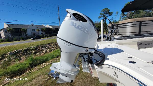 Slide: The Image of 2024 Avenger AV26 boat with Suzuki outboard motor in a residential area. - 3