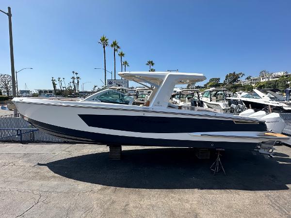 Slide: The Image of 2024 Aviara AV36 luxury boat docked at a marina under clear blue skies. - 1