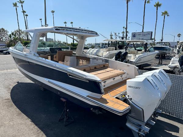 Slide: The Image of 2024 Aviara AV36 luxury boat with twin Mercury engines at a marina. - 2