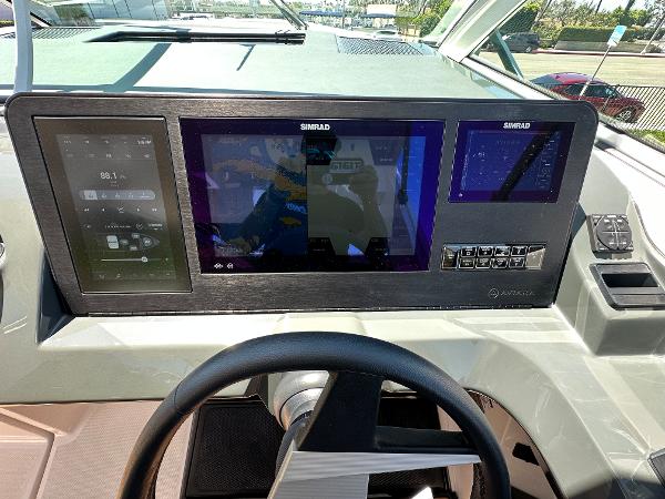 Slide: The Image of 2024 Aviara AV36 boat dashboard with Simrad navigation screens and controls. - 7