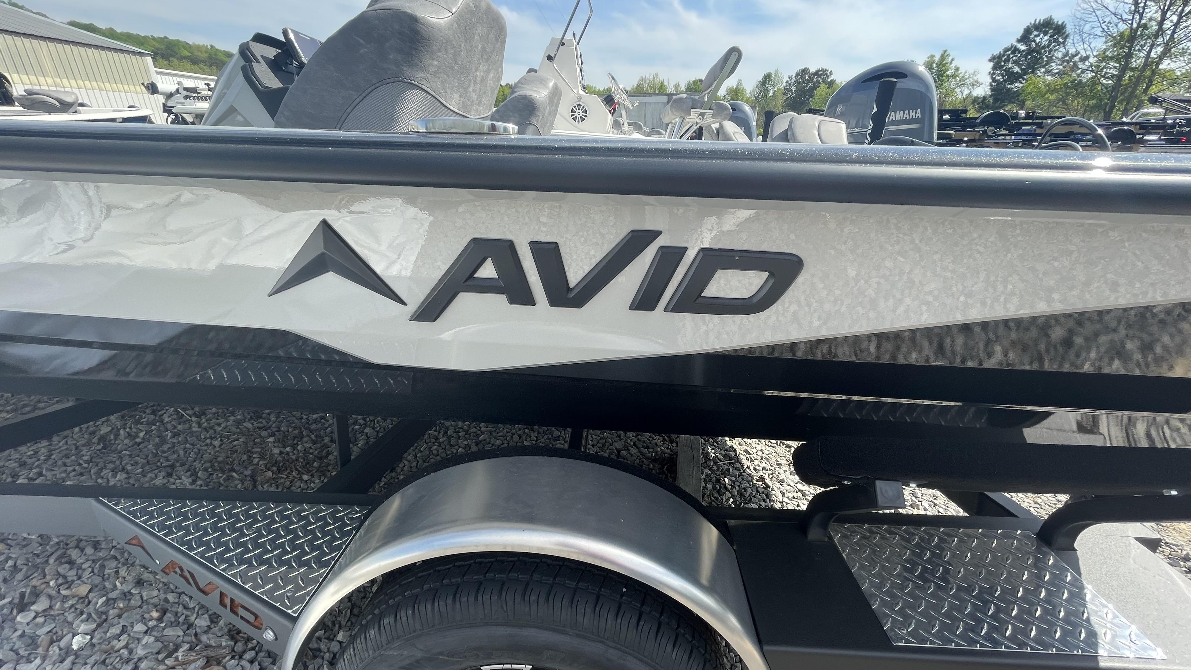 Slide: The Image of 2023 Avid 19XB boat side view with logo, parked on gravel. - 1
