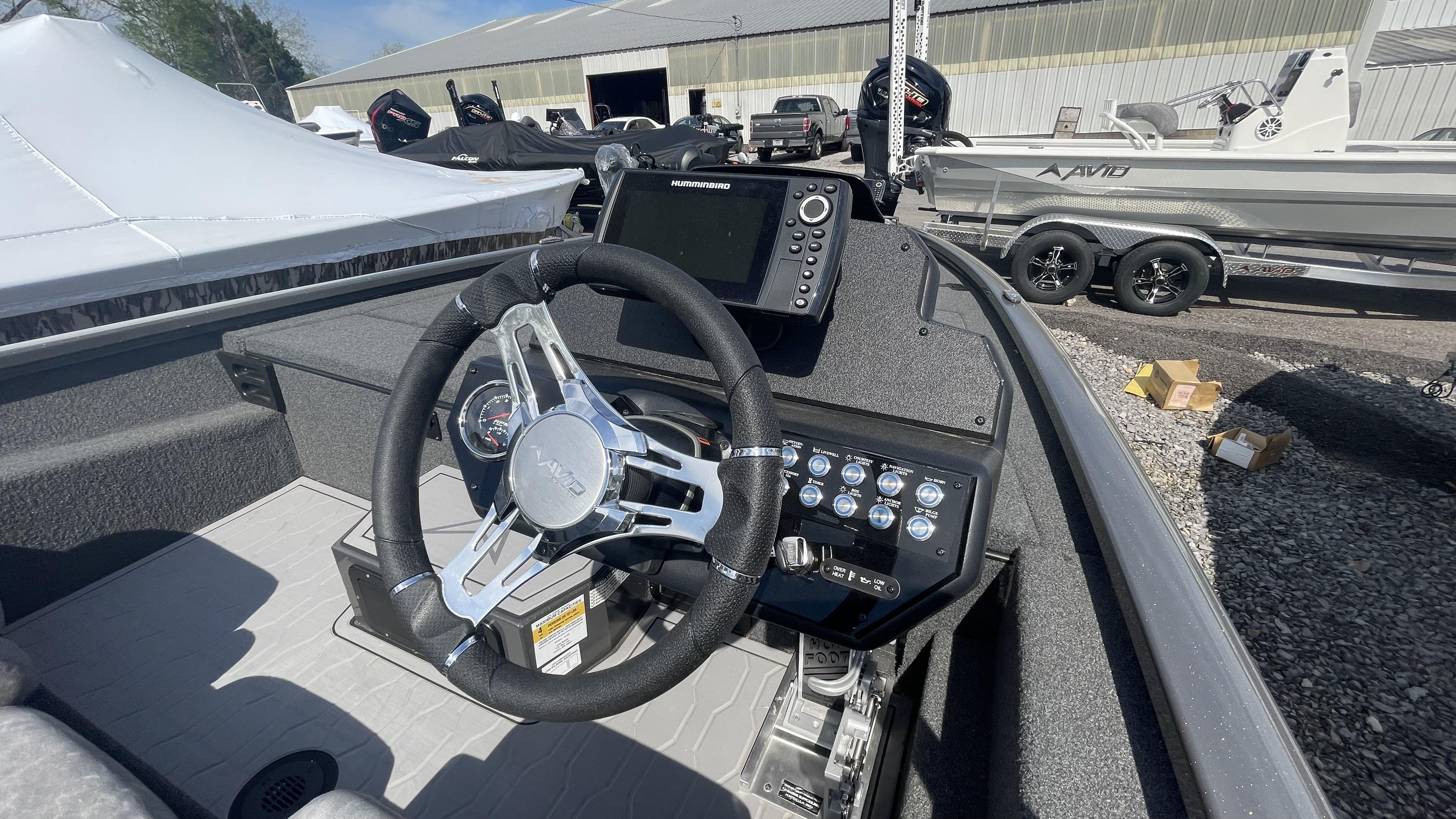 Slide: The Image of 2023 Avid 19XB boat dashboard with steering wheel and navigation system. - 13