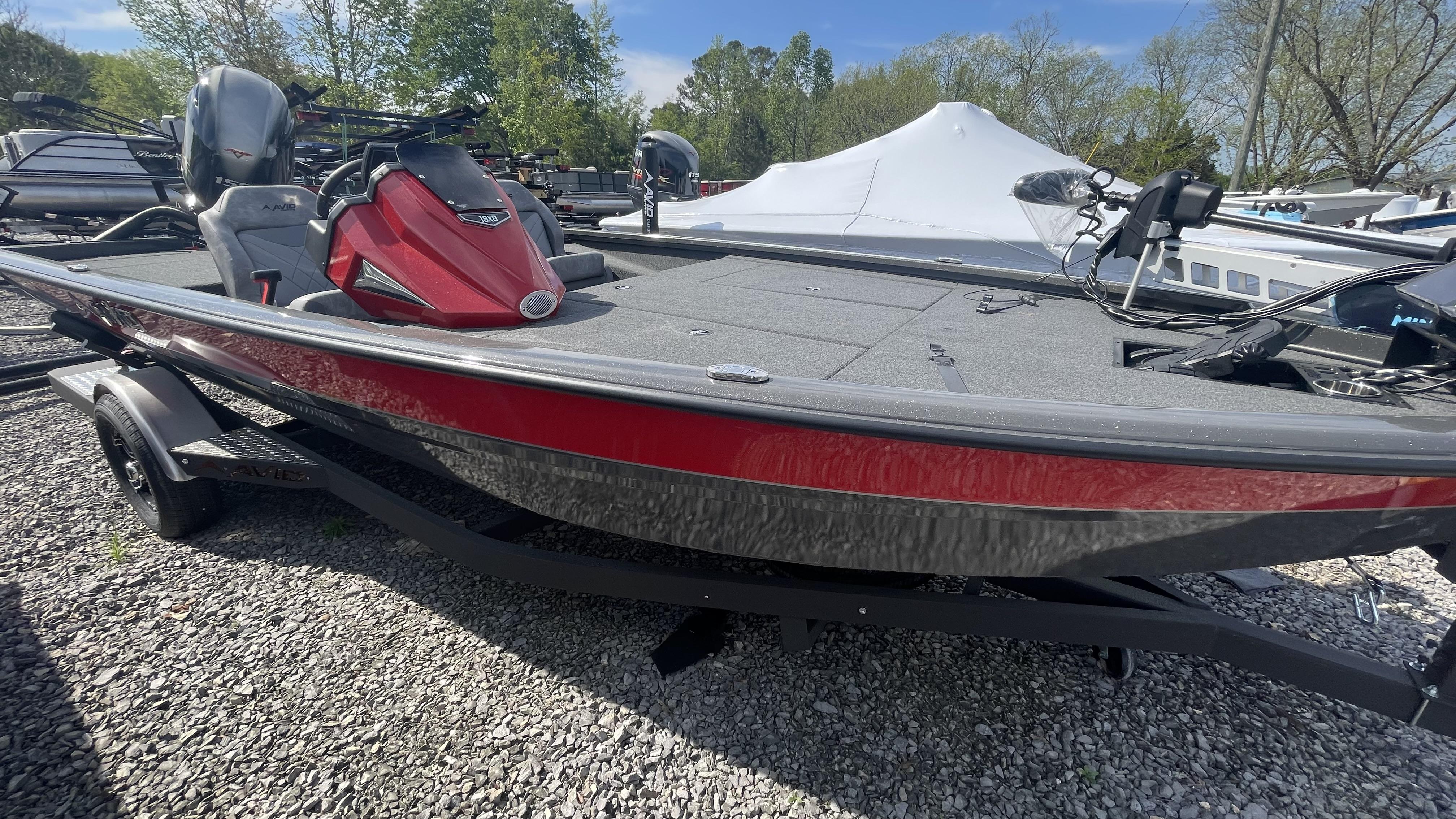 Slide: The Image of 2023 Avid 19XB boat with red and gray detailing on a trailer. - 9