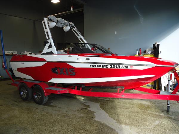 Slide: The Image of 2021 Axis A20 red and white boat on trailer in garage. - 0