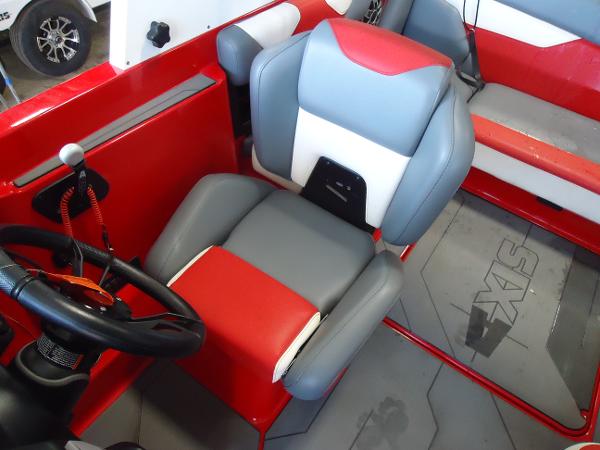 Slide: The Image of 2021 Axis A20 boat interior with red and gray captain's seat and steering wheel. - 10
