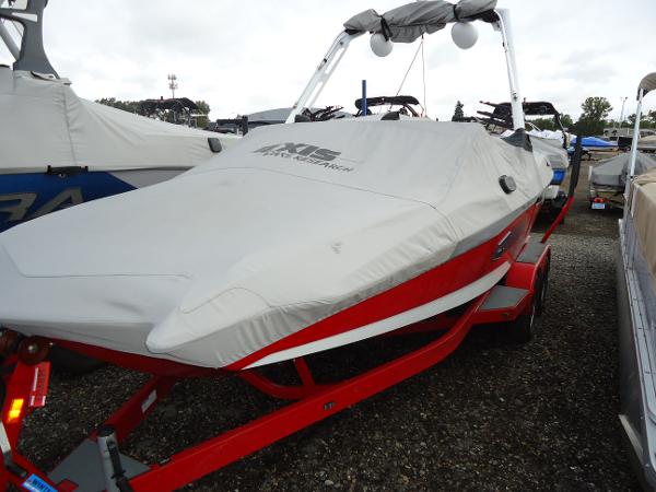 Slide: The Image of 2021 Axis A20 boat with cover on red trailer in marina. - 12