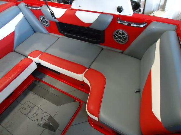 Slide: The Image of 2021 Axis A20 boat interior with red, gray, and white seating, and built-in speakers. - 7