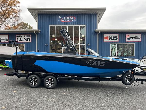 Slide: The Image of 2024 Axis A225 boat in blue and black, parked outside LHM dealership. - 1