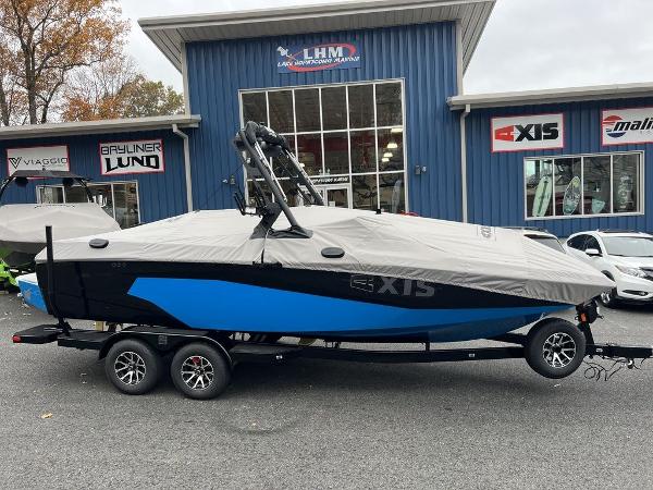 Slide: The Image of 2024 Axis A225 boat with cover on trailer outside dealership. - 12