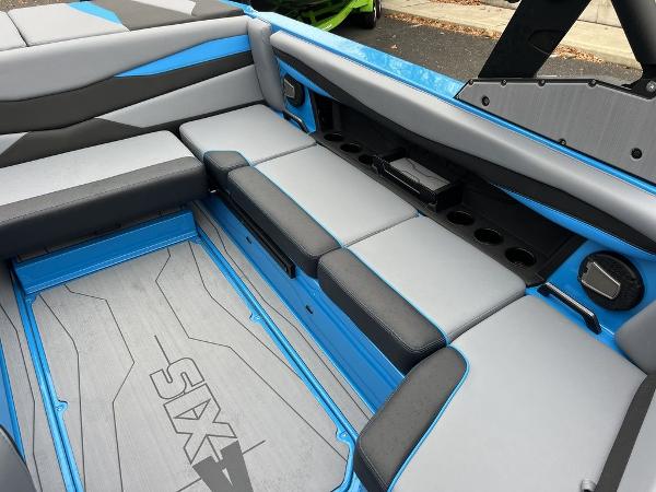Slide: The Image of 2024 Axis A225 boat interior with blue and gray seating and cup holders. - 3