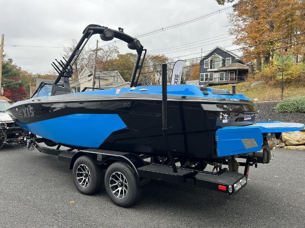 Slide: The Image of 2024 Axis A225 boat on trailer, blue and black, parked outdoors. - 5