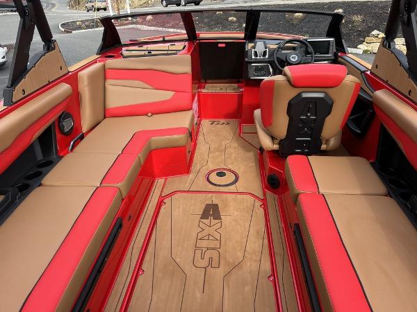 Slide: The Image of 2024 Axis T235 boat interior with red and tan seating, modern dashboard, and spacious layout. - 10