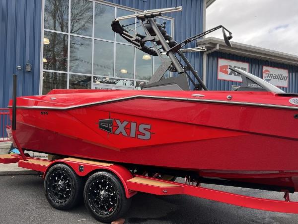 Slide: The Image of 2024 Axis T235 red wakeboard boat on a matching trailer outside a dealership. - 14