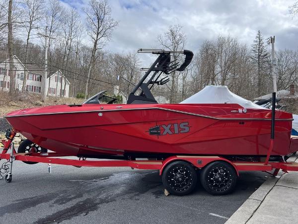 Slide: The Image of 2024 Axis T235 red boat on trailer, parked on a residential street. - 8