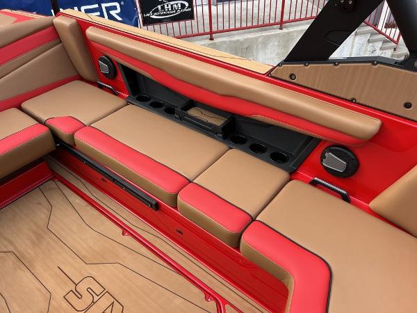 Slide: The Image of 2024 Axis T235 boat interior with red and tan seating, cup holders, and speakers. - 9