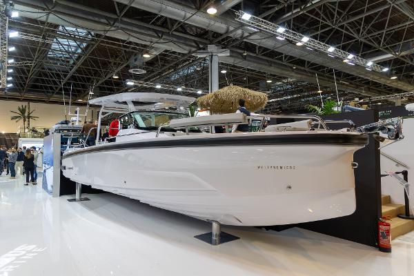 Slide: The Image of 2024 Axopar 29 Sun Top boat displayed at an indoor exhibition. - 0