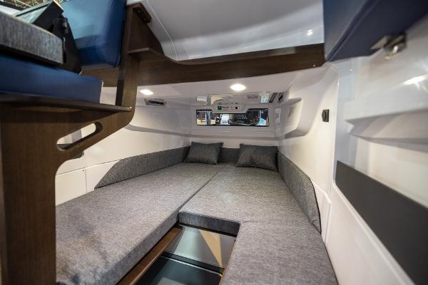 Slide: The Image of 2024 Axopar 29 Sun Top cabin interior with cozy gray bedding. - 6