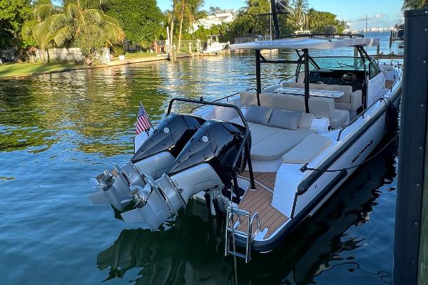 Slide: The Image of 2023 Axopar 37 Sun-Top boat docked in a scenic waterfront location. - 0